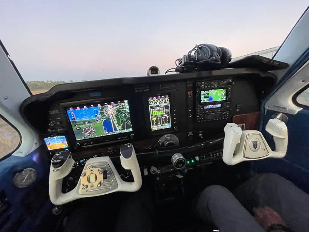 The aircraft's modern cockpit features multiple digital displays, yokes, and various control panels.