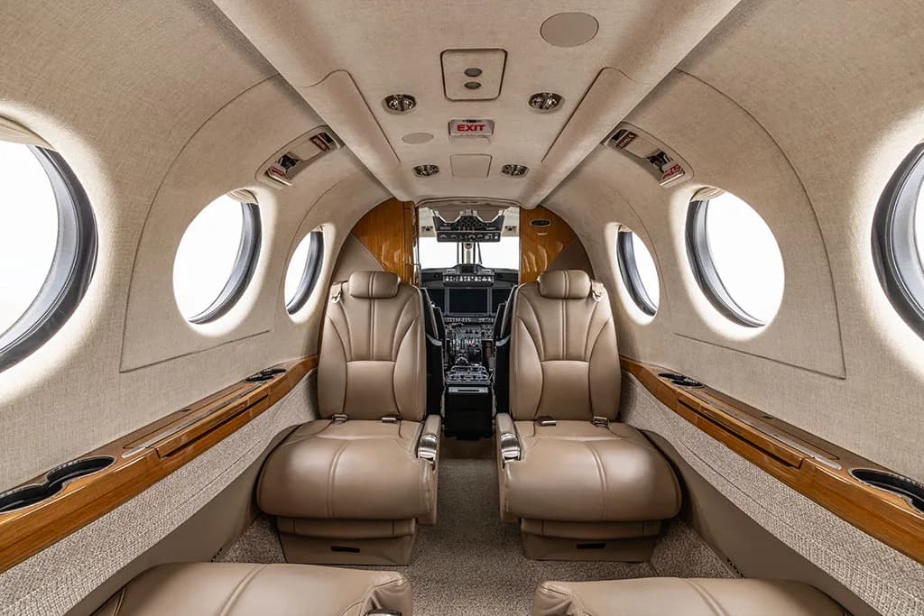 The aircraft's beige leather cabin interior, looking forward towards the cockpit.