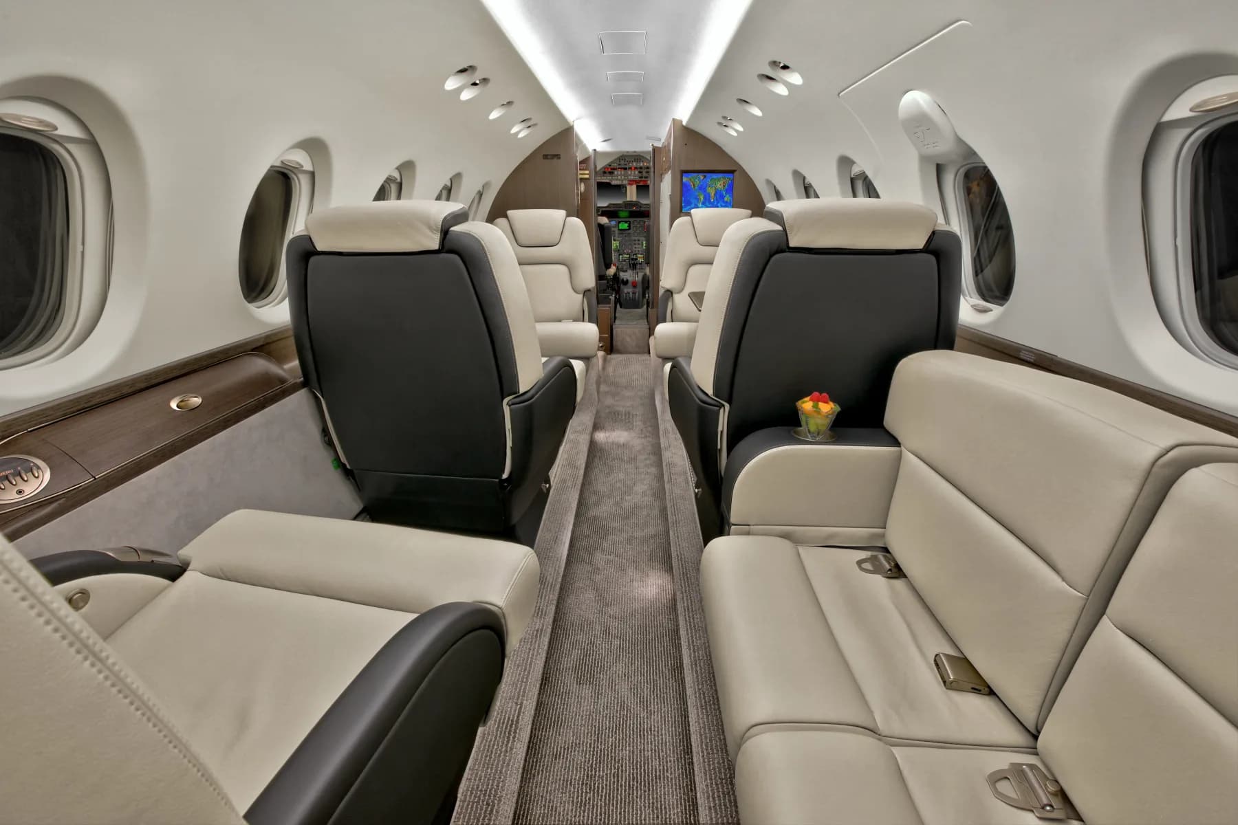 View of the aircraft's interior cabin with cream and black leather seats.