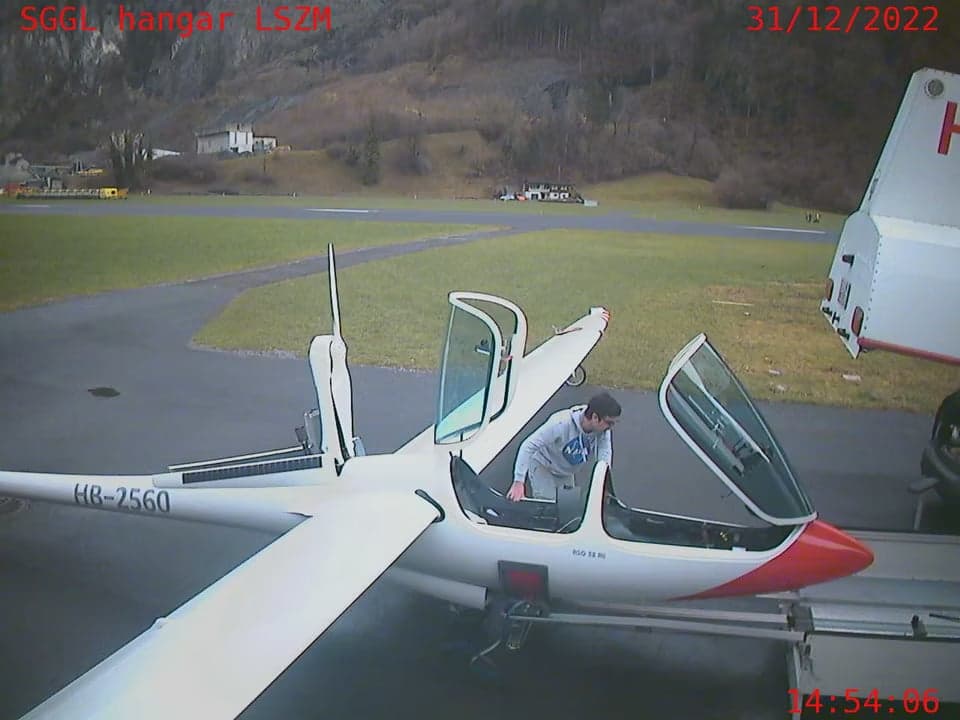 HB-2560 glider with open cockpit and a person inside.