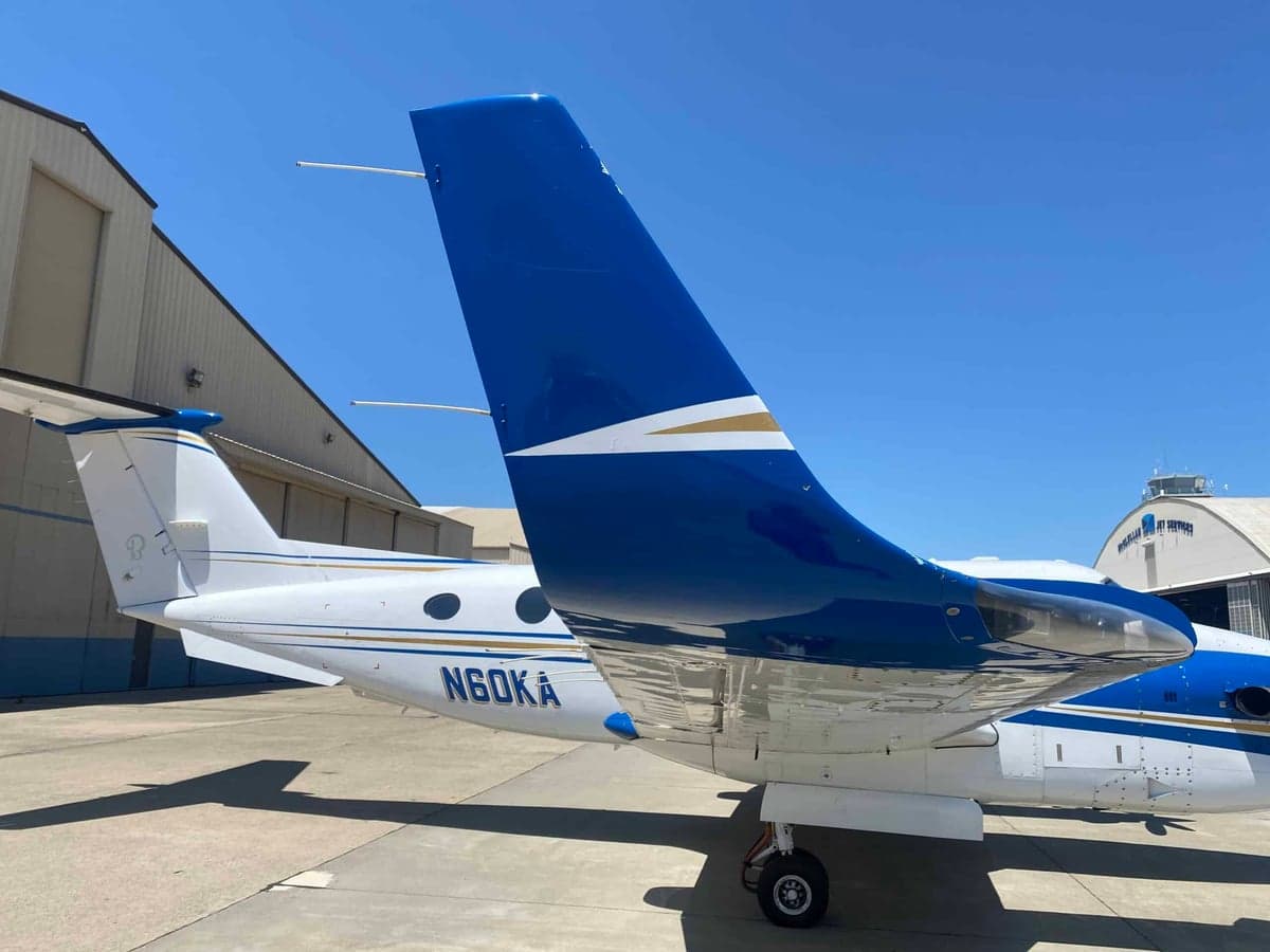 A close-up view of the blue and white tail of a Beechcraft King Air 350 with registration N60KA.