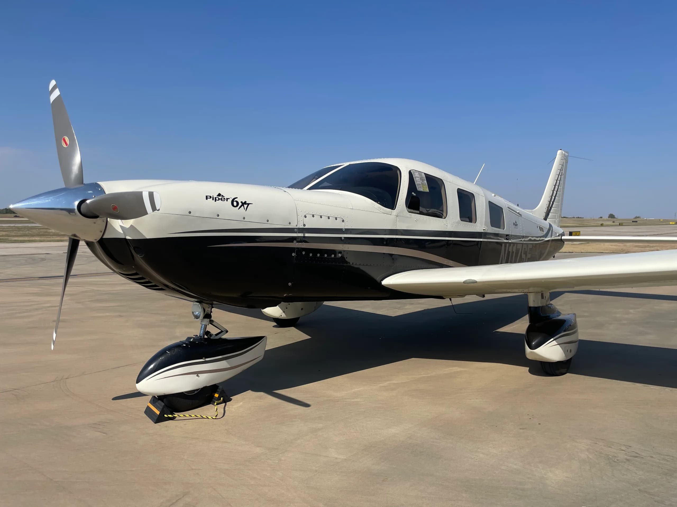 Piper PA-28 Cherokee with black and white paint scheme.