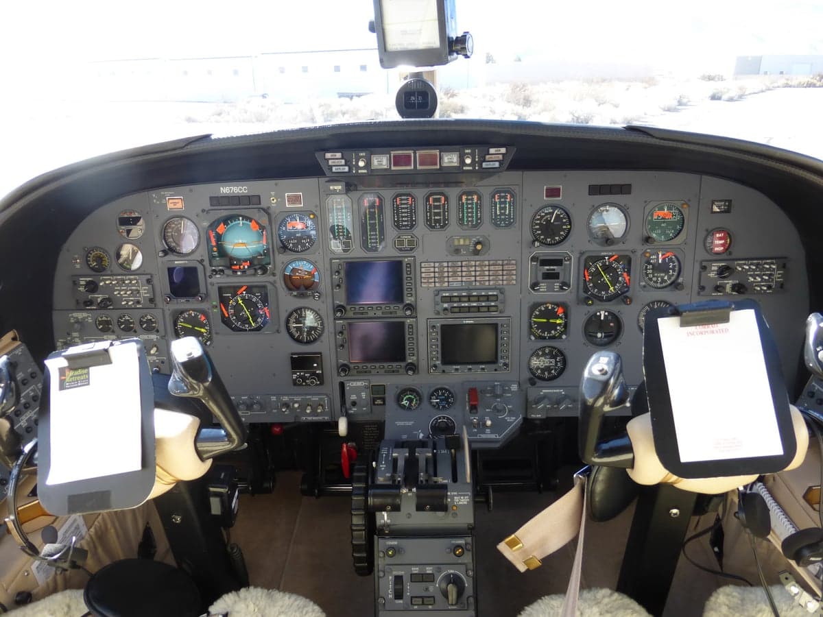 The cockpit of a Cessna Citation jet, showing the instrument panel with analog and digital displays, and control yokes.