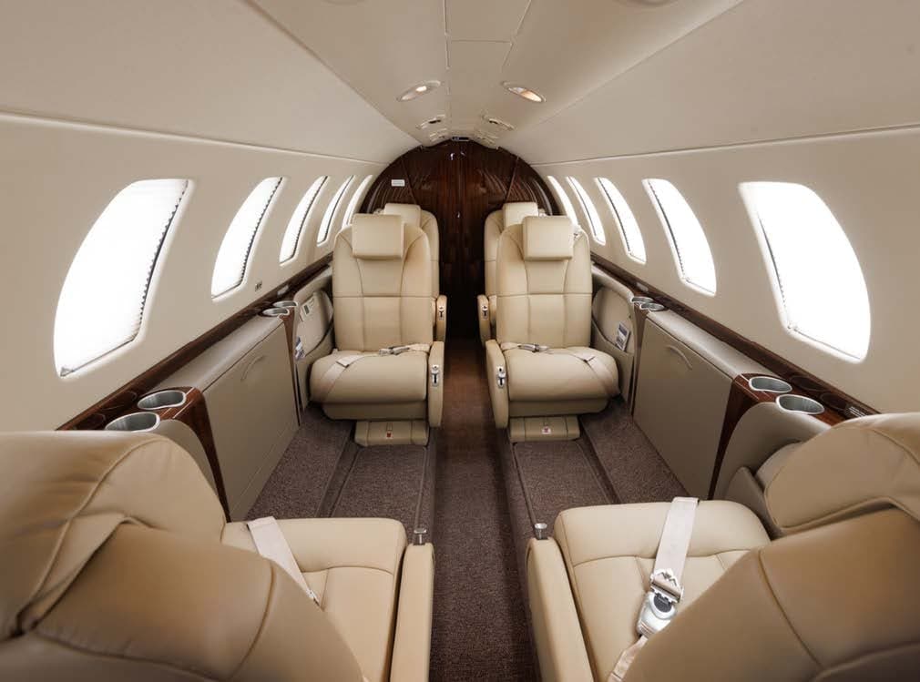A view down the aisle of the aircraft cabin, showing the leather seats.