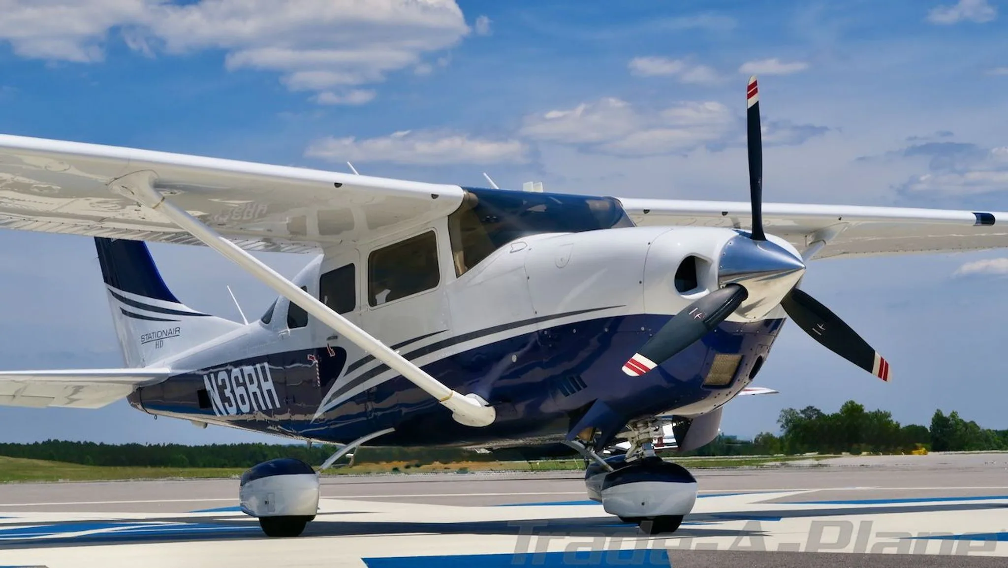 Front-right view of a white and blue Cessna Stationair HD (N36RH) on an airfield.
