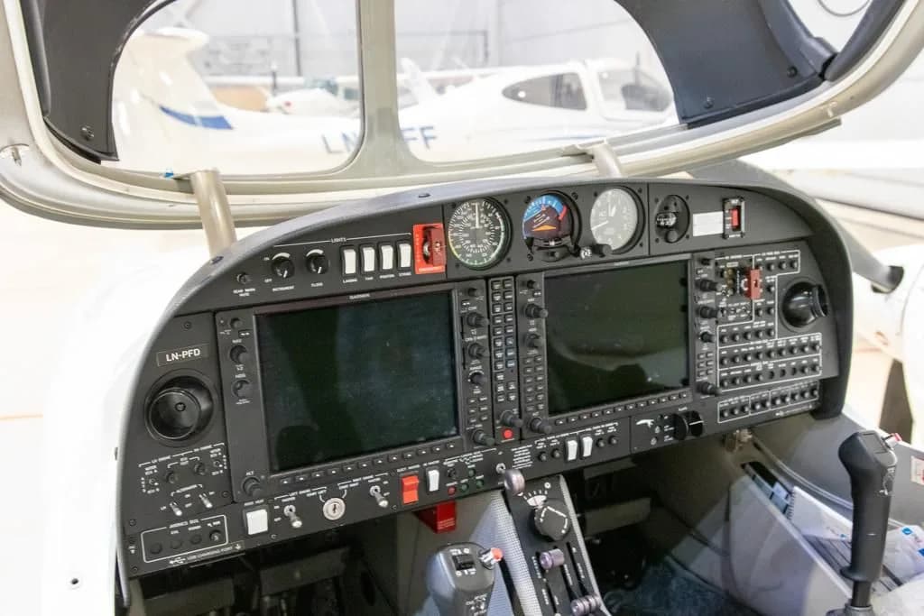 The detailed instrument panel of a Diamond DA42 aircraft, featuring multiple screens and controls.