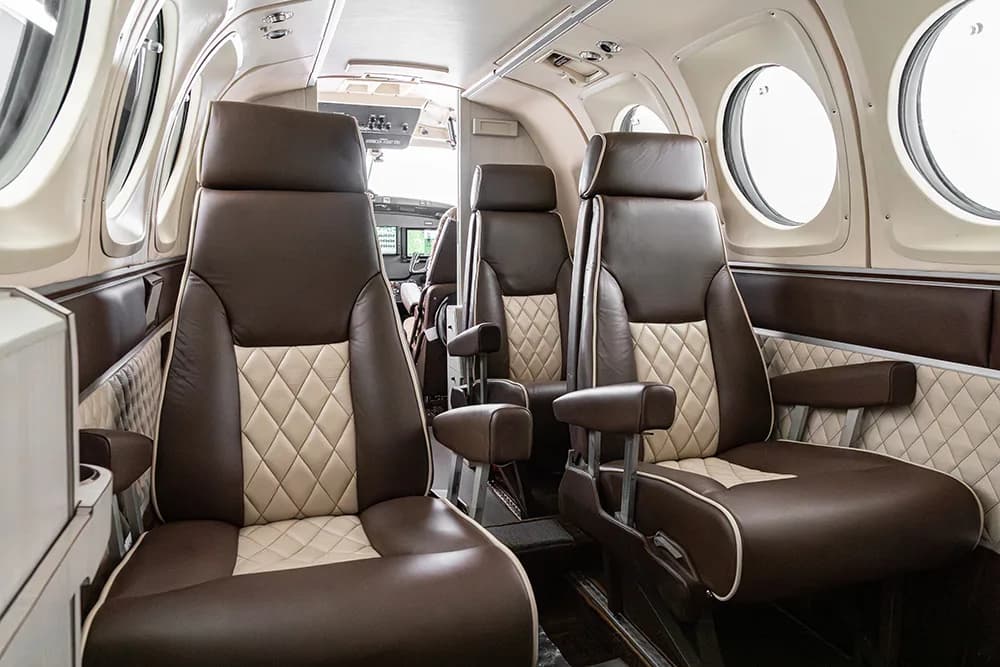 A close-up view of two brown and beige quilted aircraft seats in the cabin.