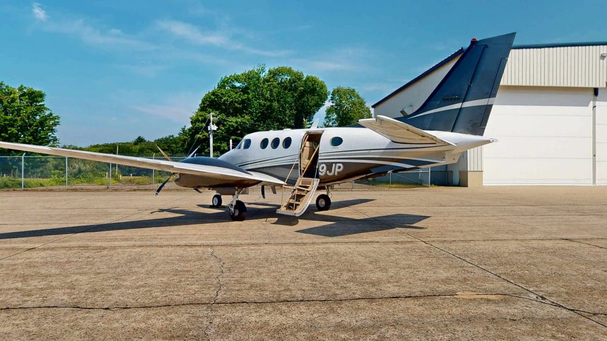 A twin turboprop aircraft with the airstair door open.