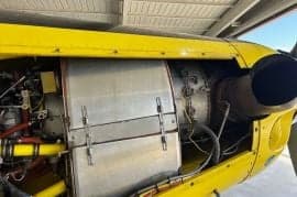 Close up of the engine of a yellow Air Tractor aircraft.