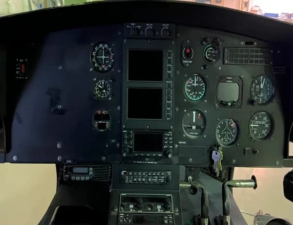Helicopter cockpit instrument panel with various gauges and controls.