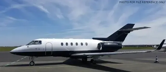 A black and white jet aircraft is parked on the tarmac.