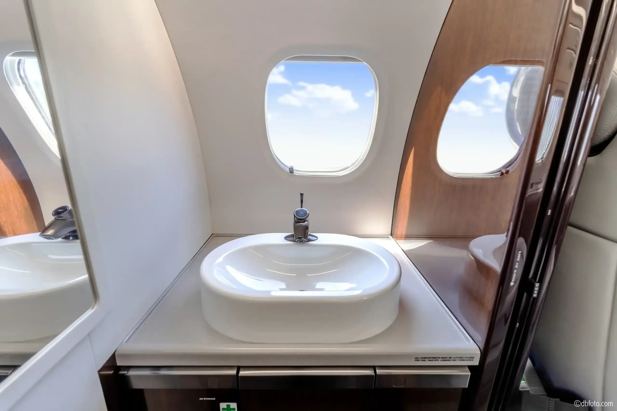 Aircraft lavatory with sink and window.