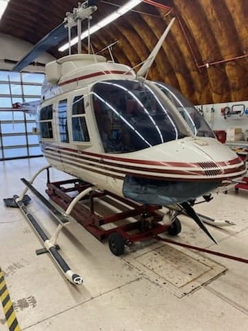 A Bell 206L-4 LongRanger helicopter in a hangar.