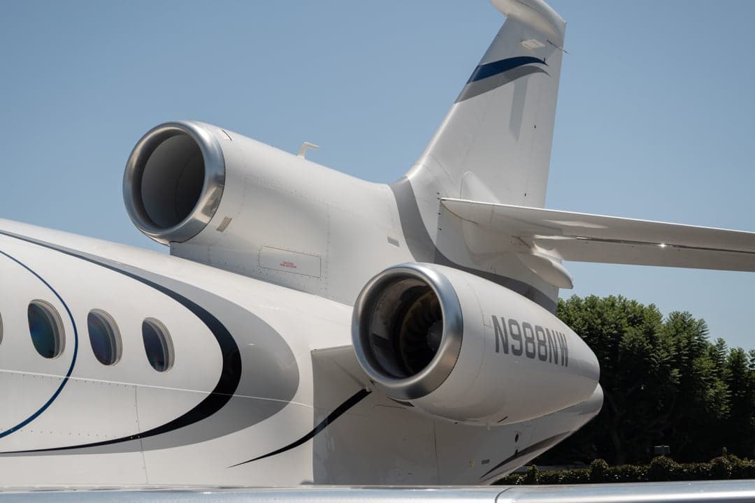 Close up of the tail and engines of the white N988NW aircraft.