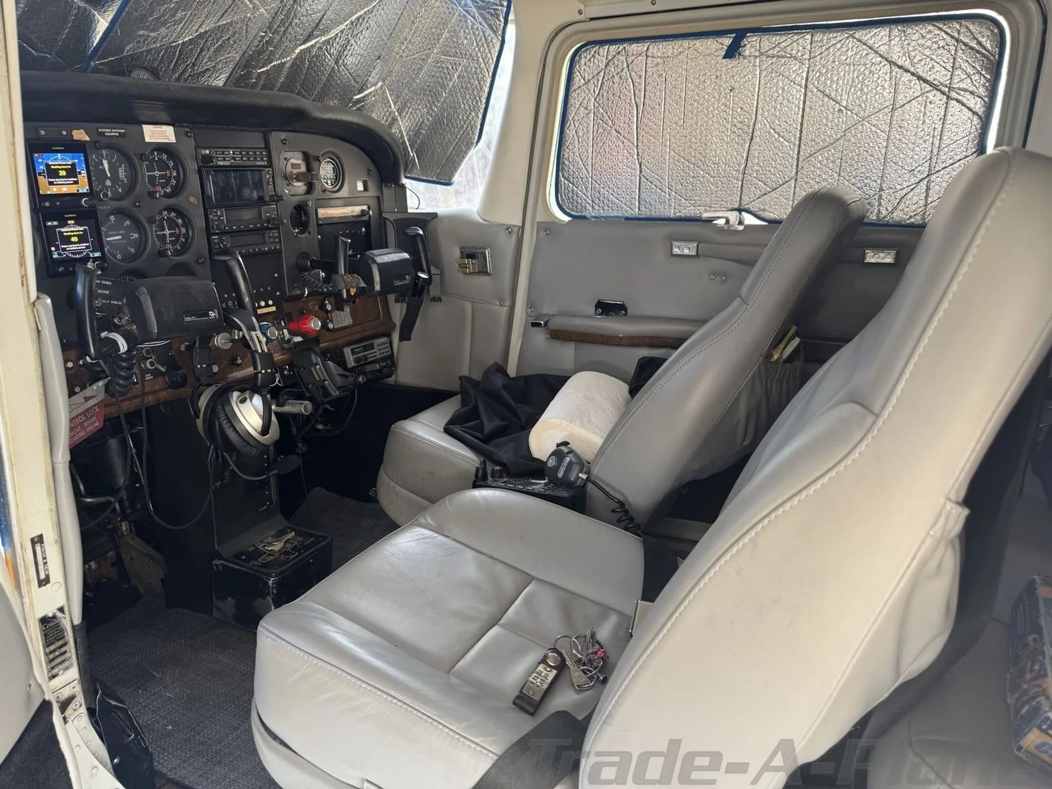 The light gray leather interior of the Cessna 182 Skylane, showing the front seats and the instrument panel.
