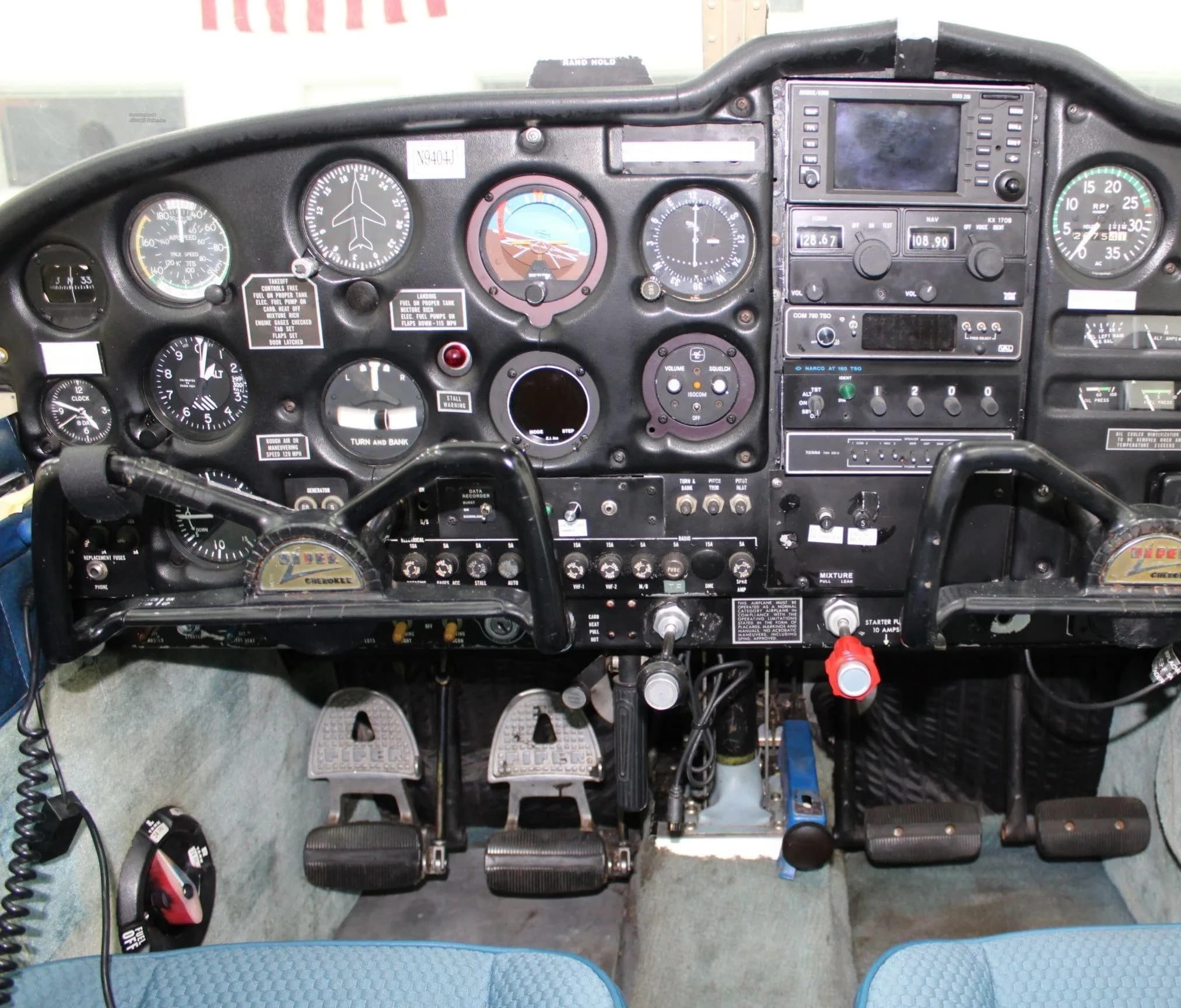 Detailed view of the instrument panel, yokes, and rudder pedals in an aircraft cockpit.