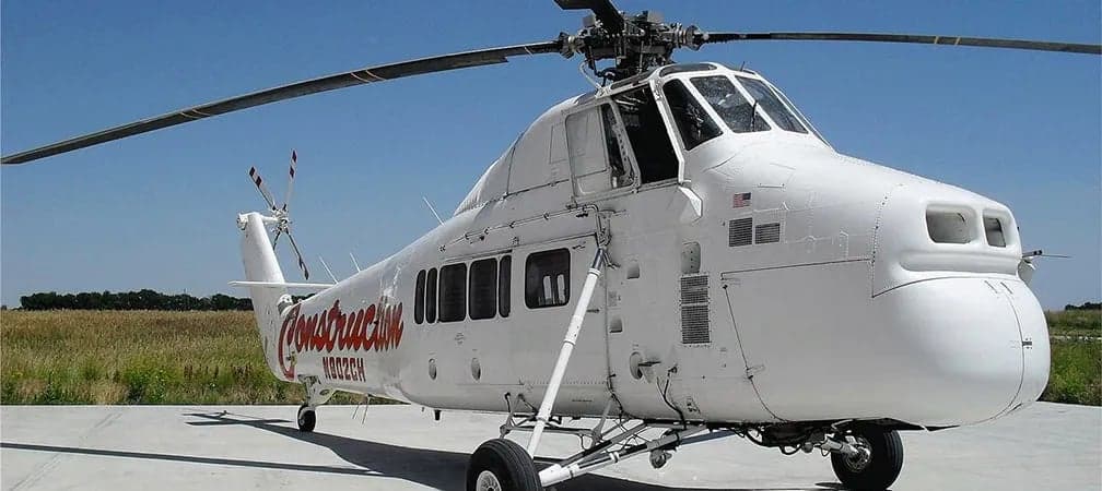 A Sikorsky S-58 helicopter is parked on the tarmac.