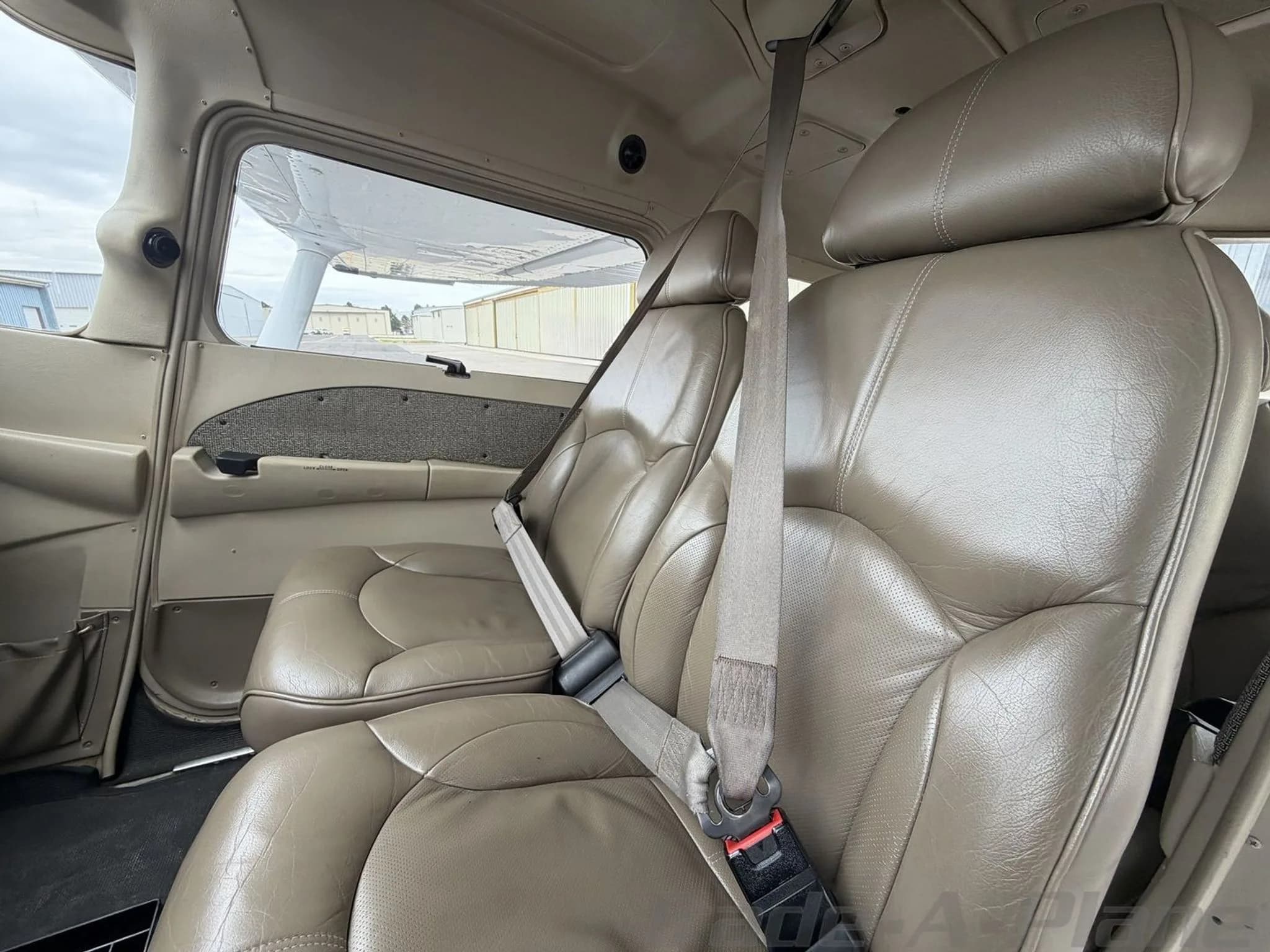 The tan leather front passenger seats of a Cessna 172 Skyhawk cabin.