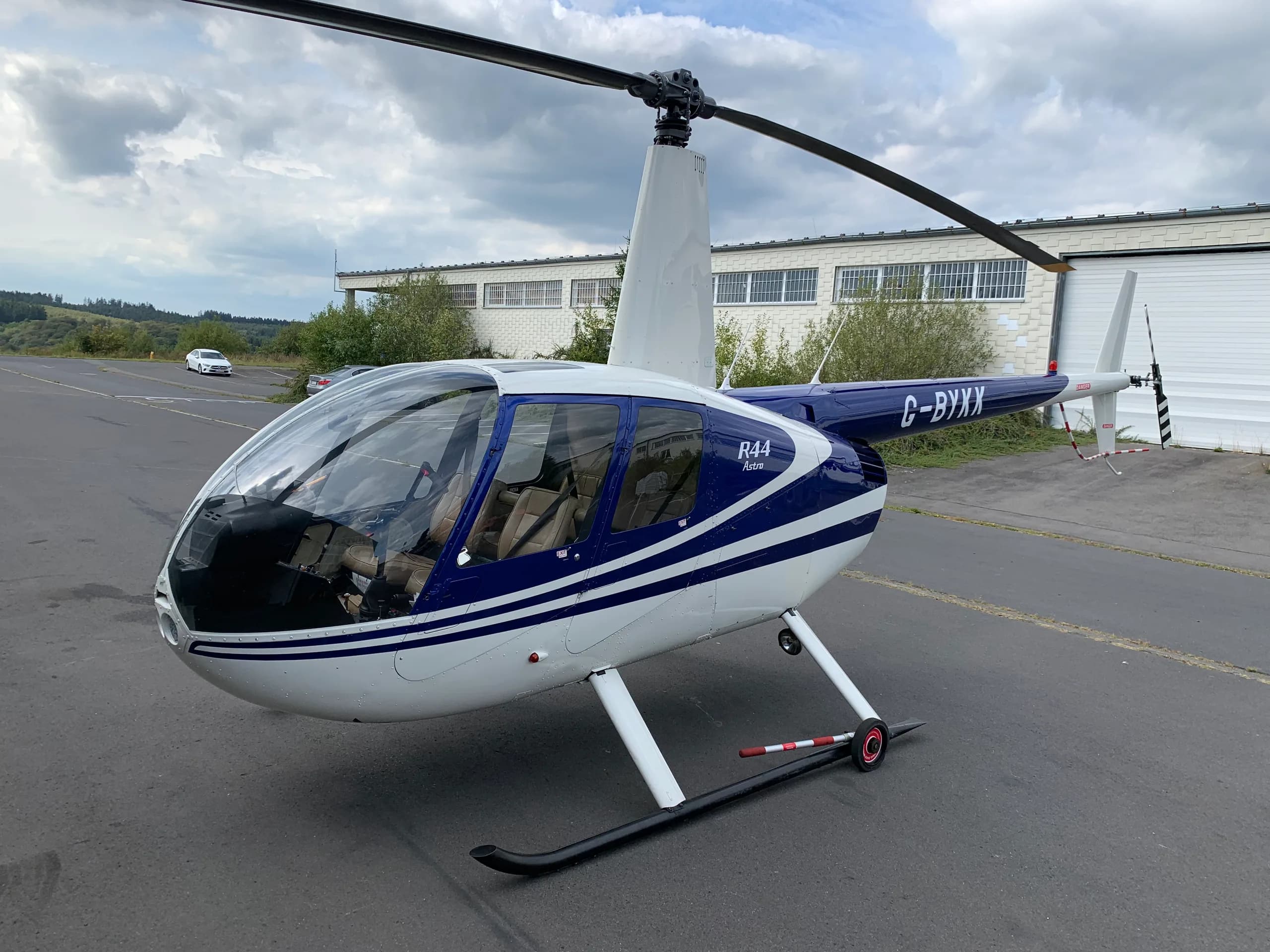 Robinson R44 Raven with blue and white paint scheme at an airport.