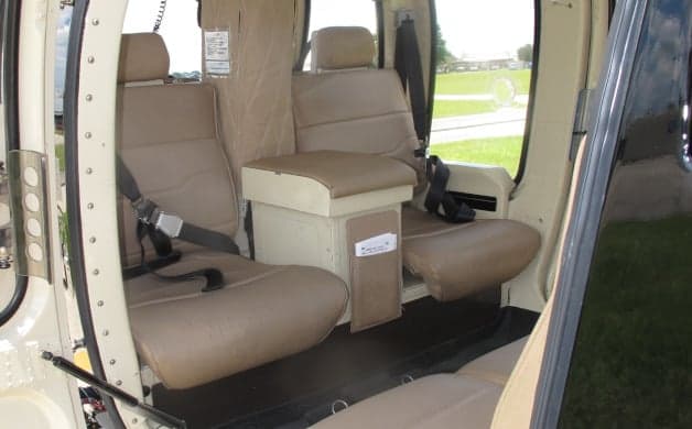 The tan leather passenger seats in the rear cabin of a helicopter.