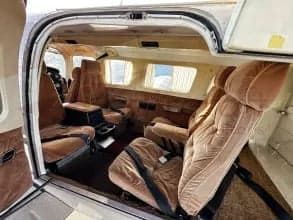 The interior of the aircraft features brown seats and carpet.