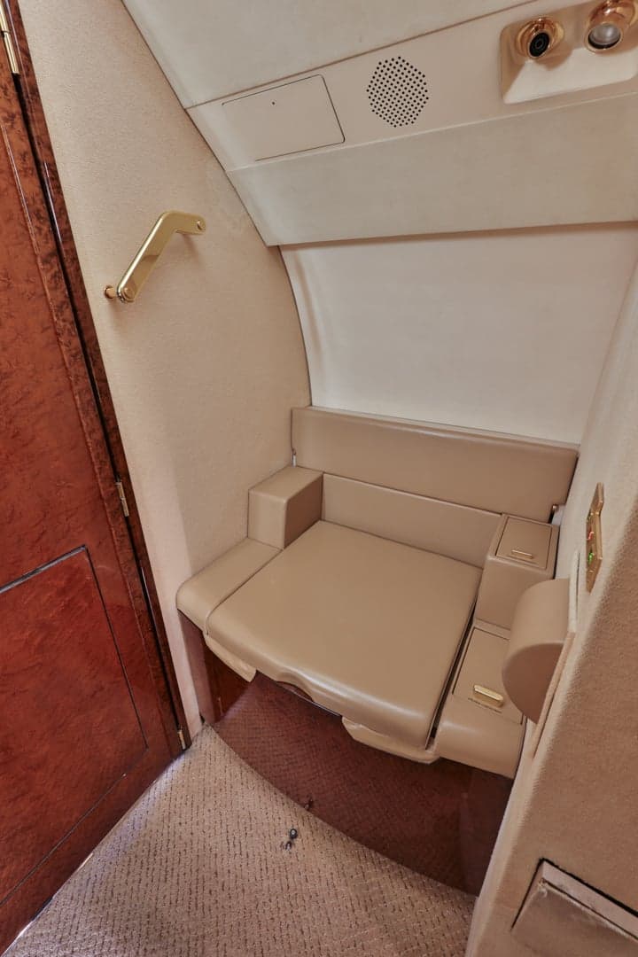 View of the aircraft lavatory seat with wood paneling.