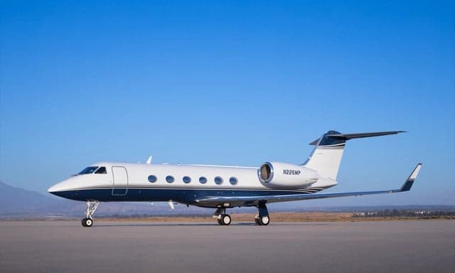 Gulfstream business jet with blue and white paint scheme on the tarmac.