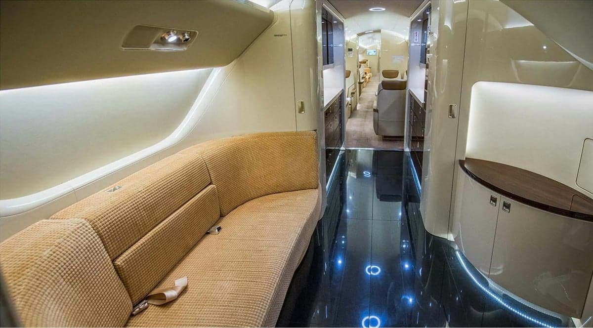 A view of the aircraft's interior, featuring a tan couch and dark flooring.