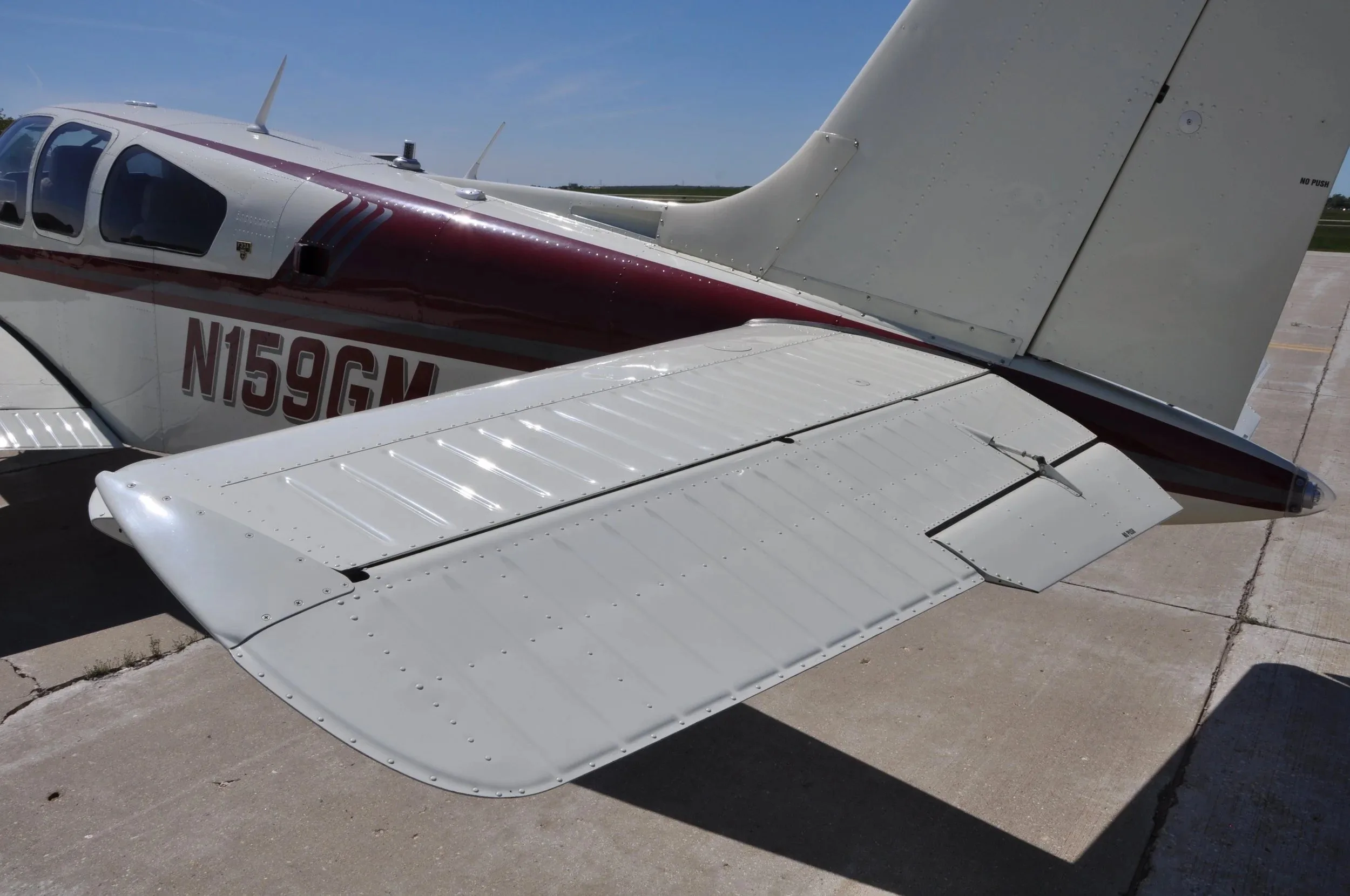 A close-up view of the right horizontal stabilizer and rear fuselage of the Beechcraft Bonanza F33A N159GM.