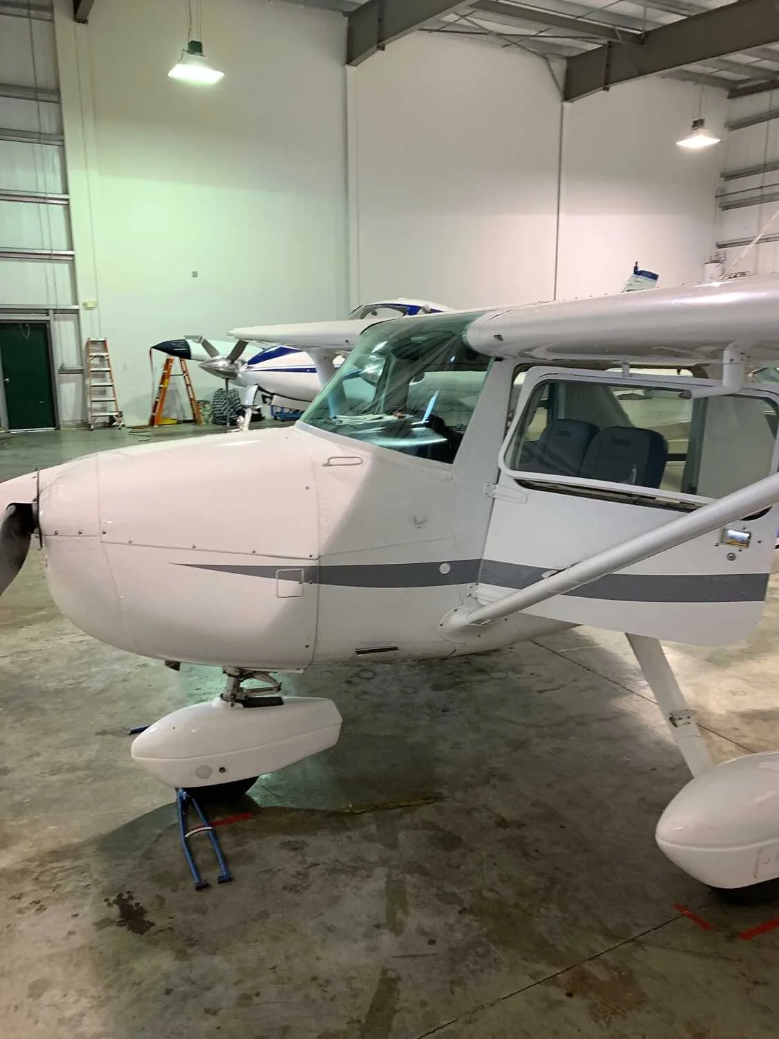 Cessna 172 Skyhawk in a hangar, front quarter view.