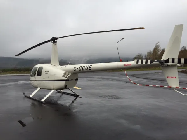 Robinson R44 Raven on the tarmac with a white paint scheme.