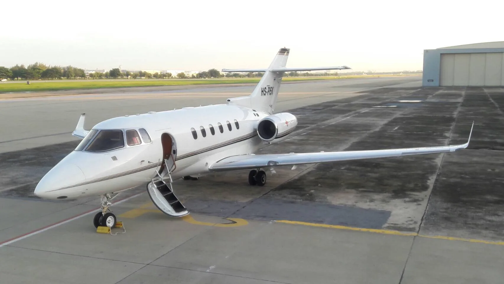 HS-PGI aircraft parked on the tarmac with the door open and stairs extended.