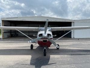 Front view of the Cessna Skylane N42974 parked in front of a hangar.