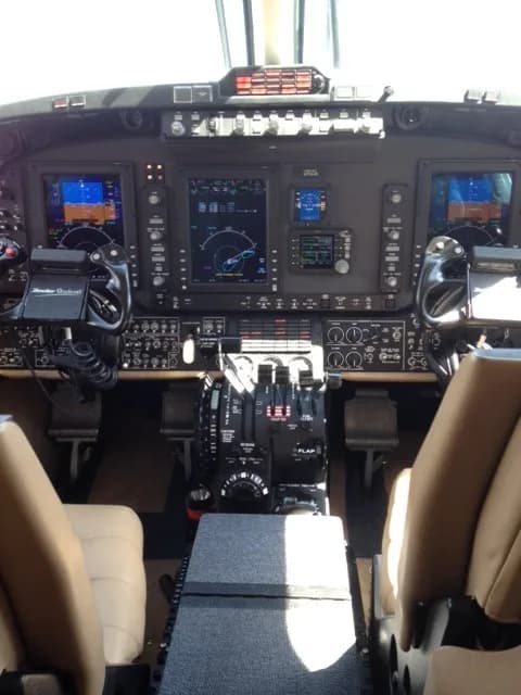 View of the cockpit instrument panel and seats of the Beechcraft King Air 350i.