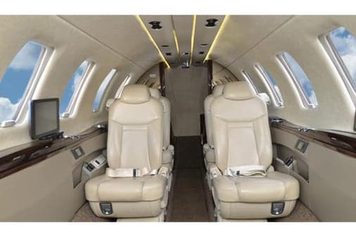 Aircraft interior featuring leather seats and cabin windows.