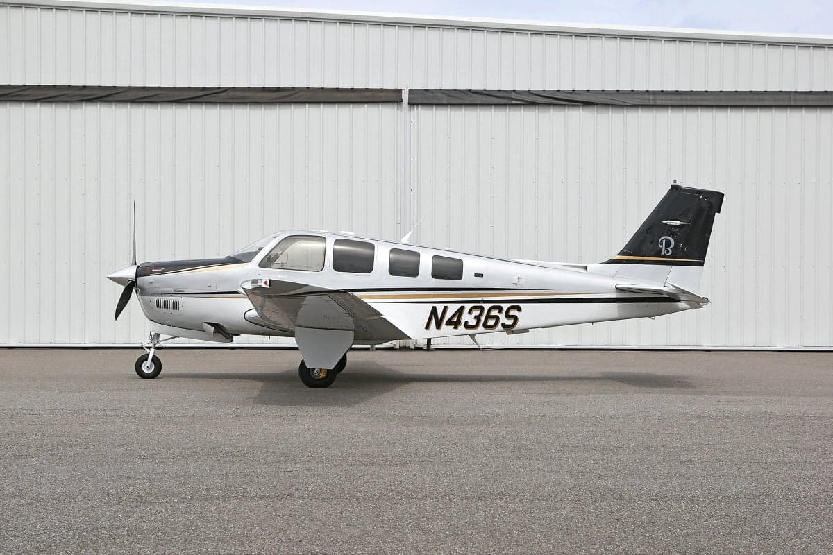 Side view of a silver and white Beechcraft Bonanza with tail number N436S.