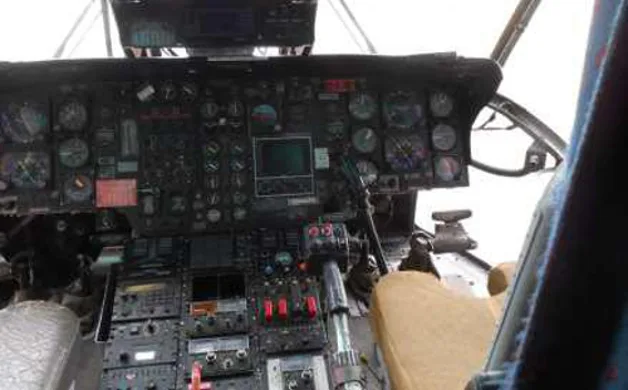 The cockpit of a helicopter displays numerous gauges, screens, and control panels.