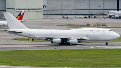 A Boeing 747 aircraft in white livery is on the tarmac.