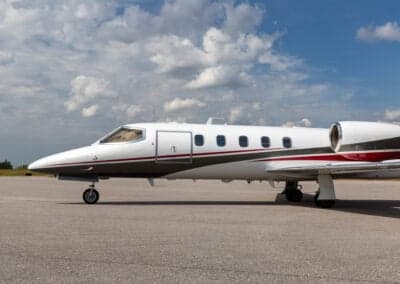 A Learjet 45XR aircraft is parked on the tarmac, showing the side door.