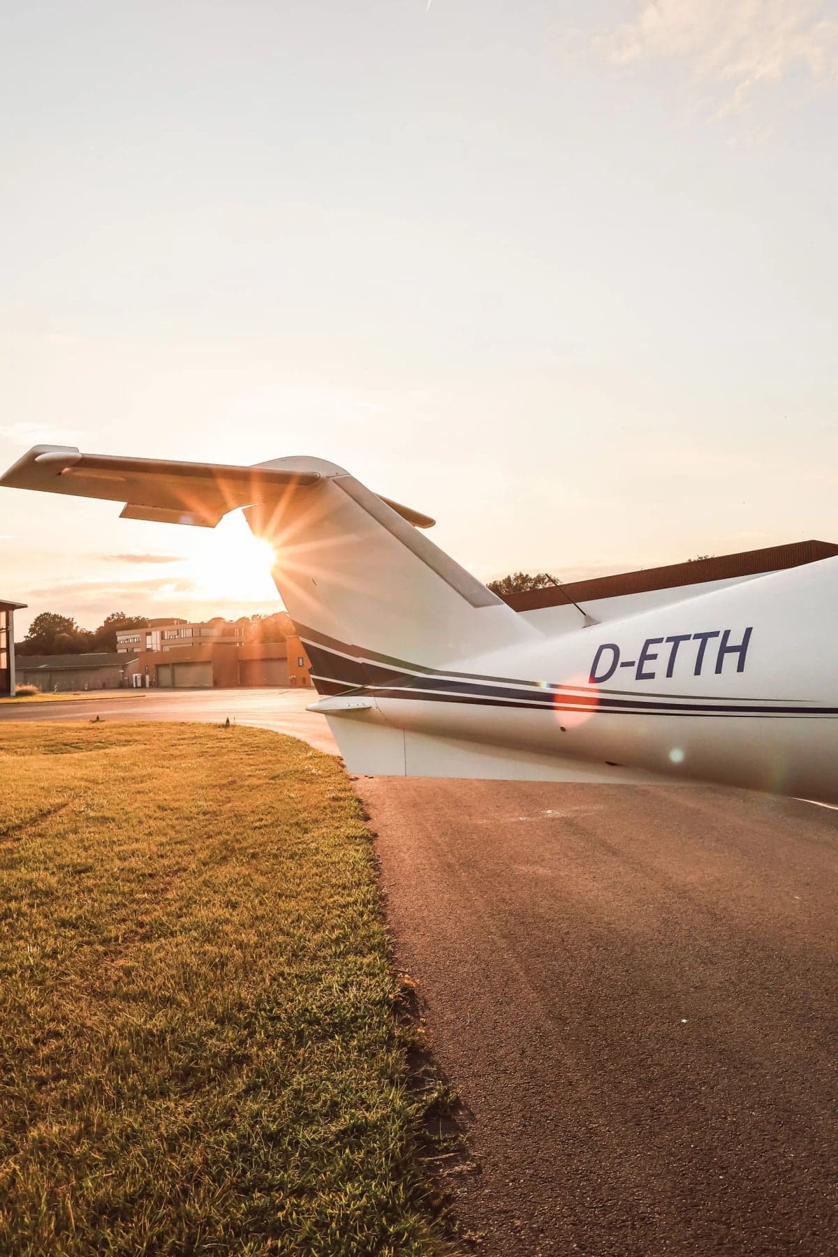 Tail of the Extra 400 aircraft D-ETTH with the sun shining behind it.