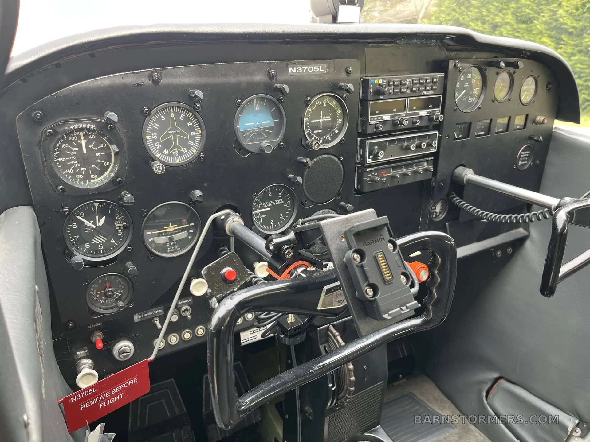 The black instrument panel of a Cessna Skyhawk (N3705L) features analog gauges, radio stack, and a control yoke with a Garmin mount.