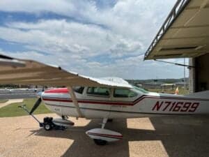 Side view of a Cessna 182 Skylane, registration N71699, parked on a paved surface with a tow bar attached.