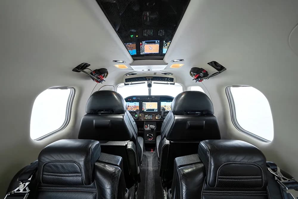 Interior view of the aircraft cabin from the rear seats looking towards the cockpit.
