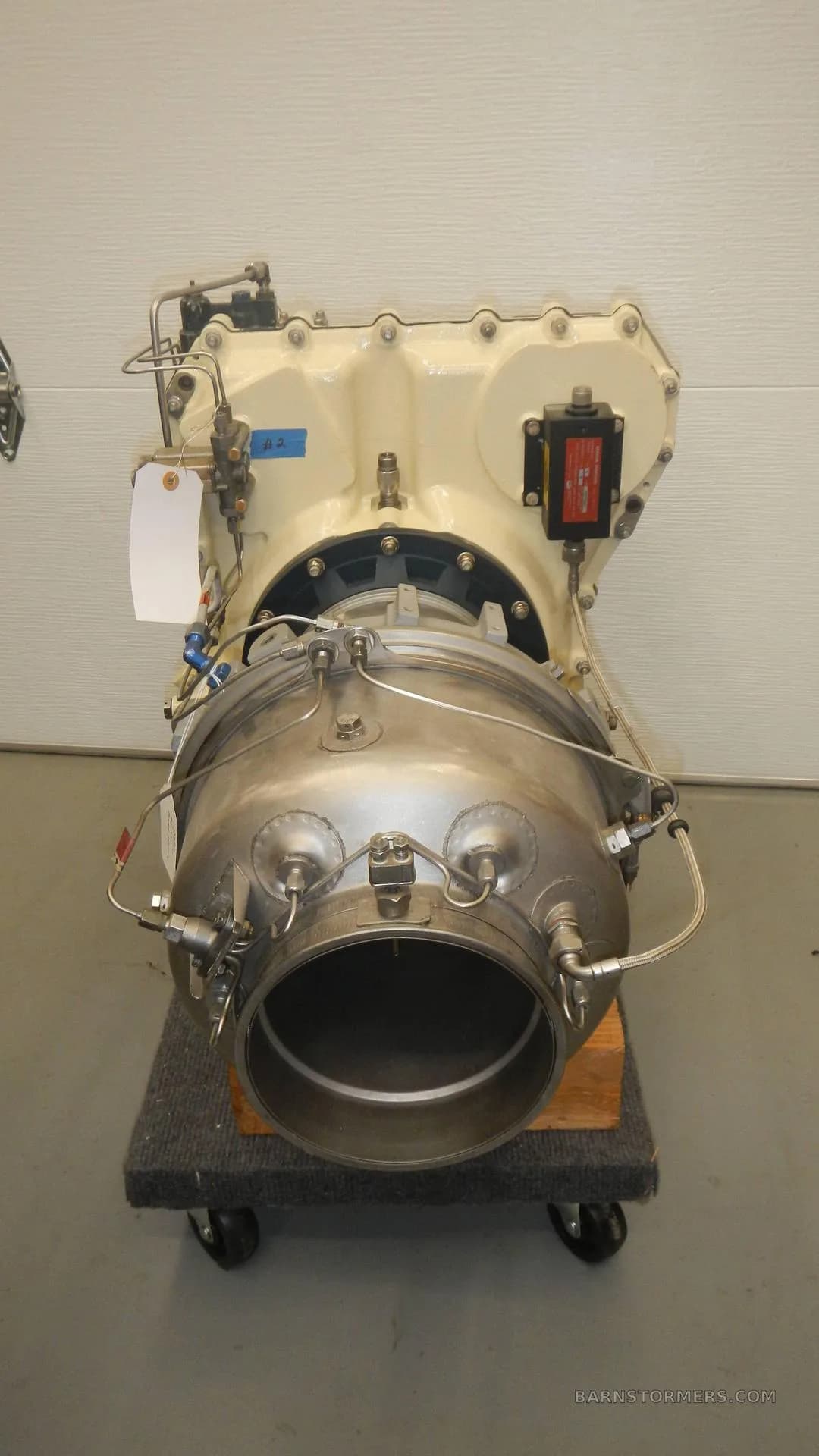 A front view of a turboprop or turboshaft aircraft engine on a rolling stand.