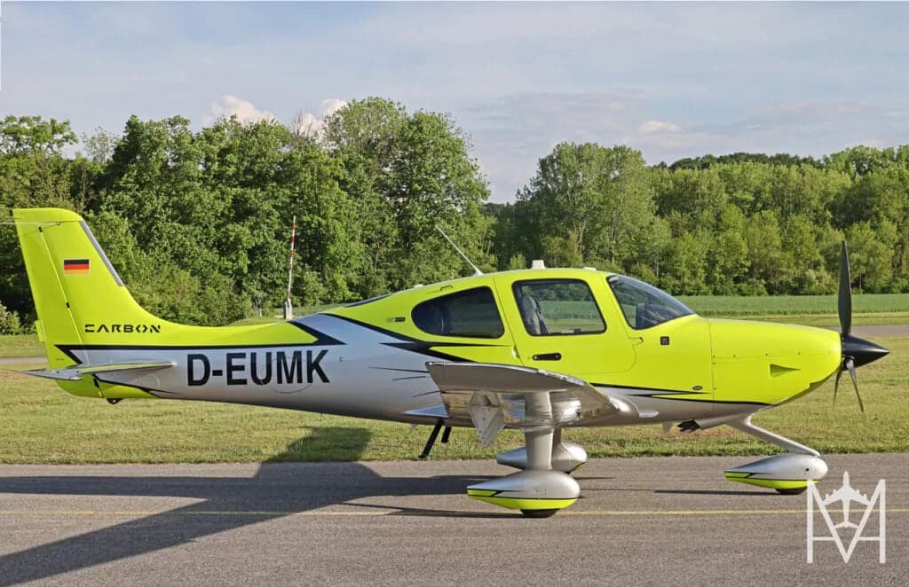 A bright yellow and silver Carbon Cub aircraft parked on the tarmac.