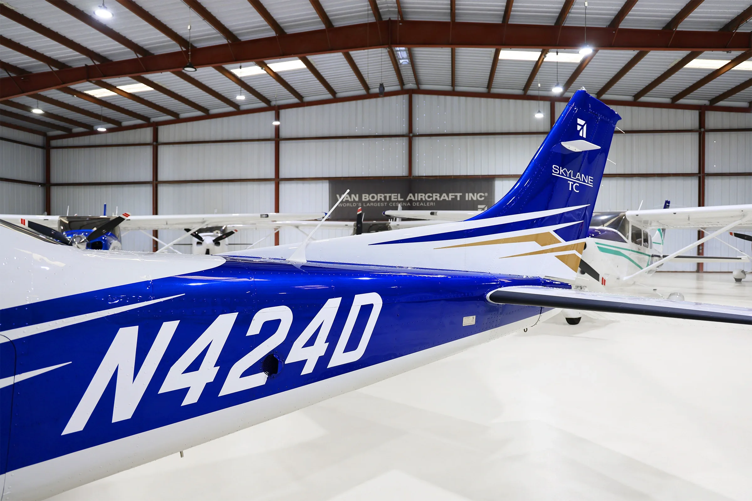 A close-up of the blue tail of the Cessna Skylane N424D with white registration and gold accents.