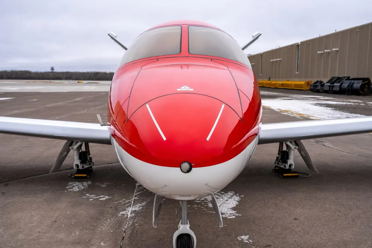 Close-up front view of the red and white Cirrus Vision Jet nose.