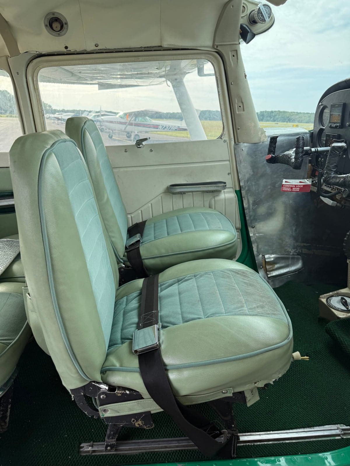 Front seats of the Cessna 172 Skyhawk with green upholstery.