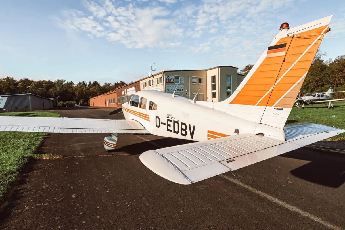 Piper Dakota D-EDBV with orange tail stripes parked on the tarmac.
