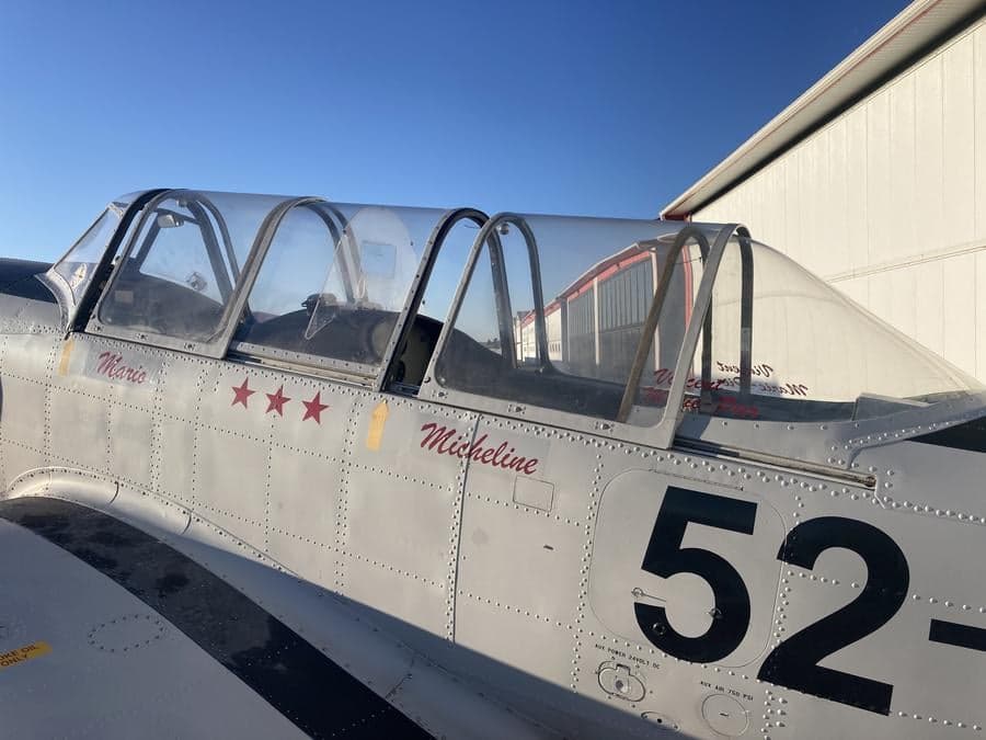 Close-up of the cockpit area of a Yak-52TW aircraft with bubble canopies.